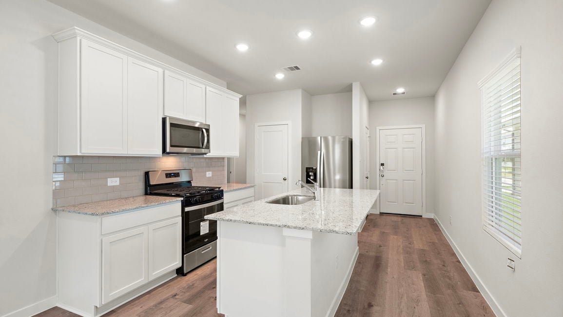 A kitchen with white cabinets.