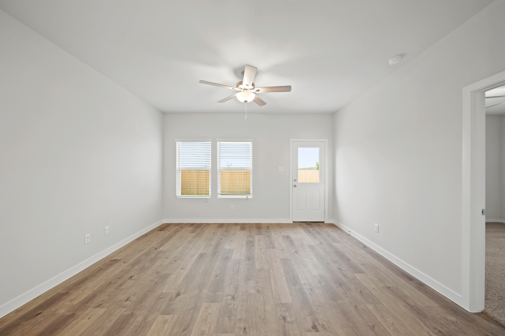 A room with a wood floor and a ceiling fan.