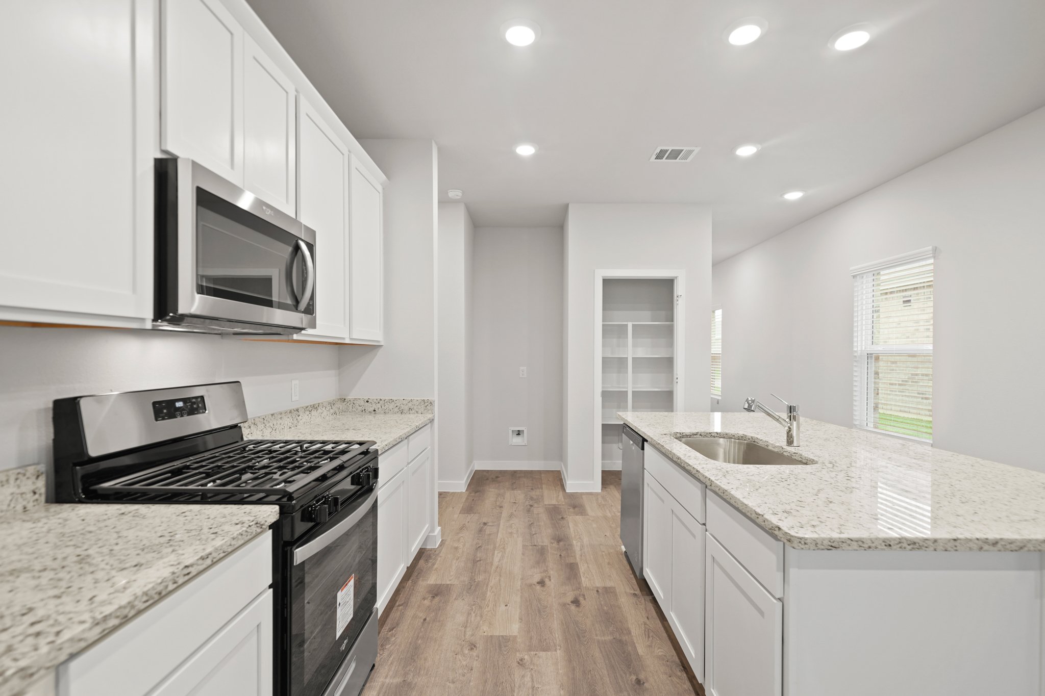 A kitchen with white cabinets.