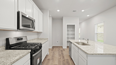 A kitchen with white cabinets.
