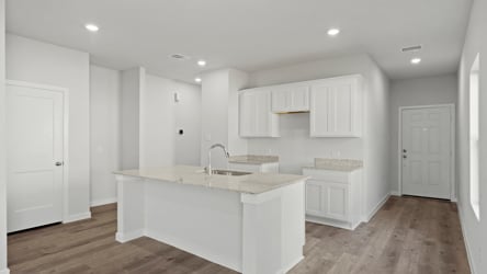 A kitchen with white cabinets.