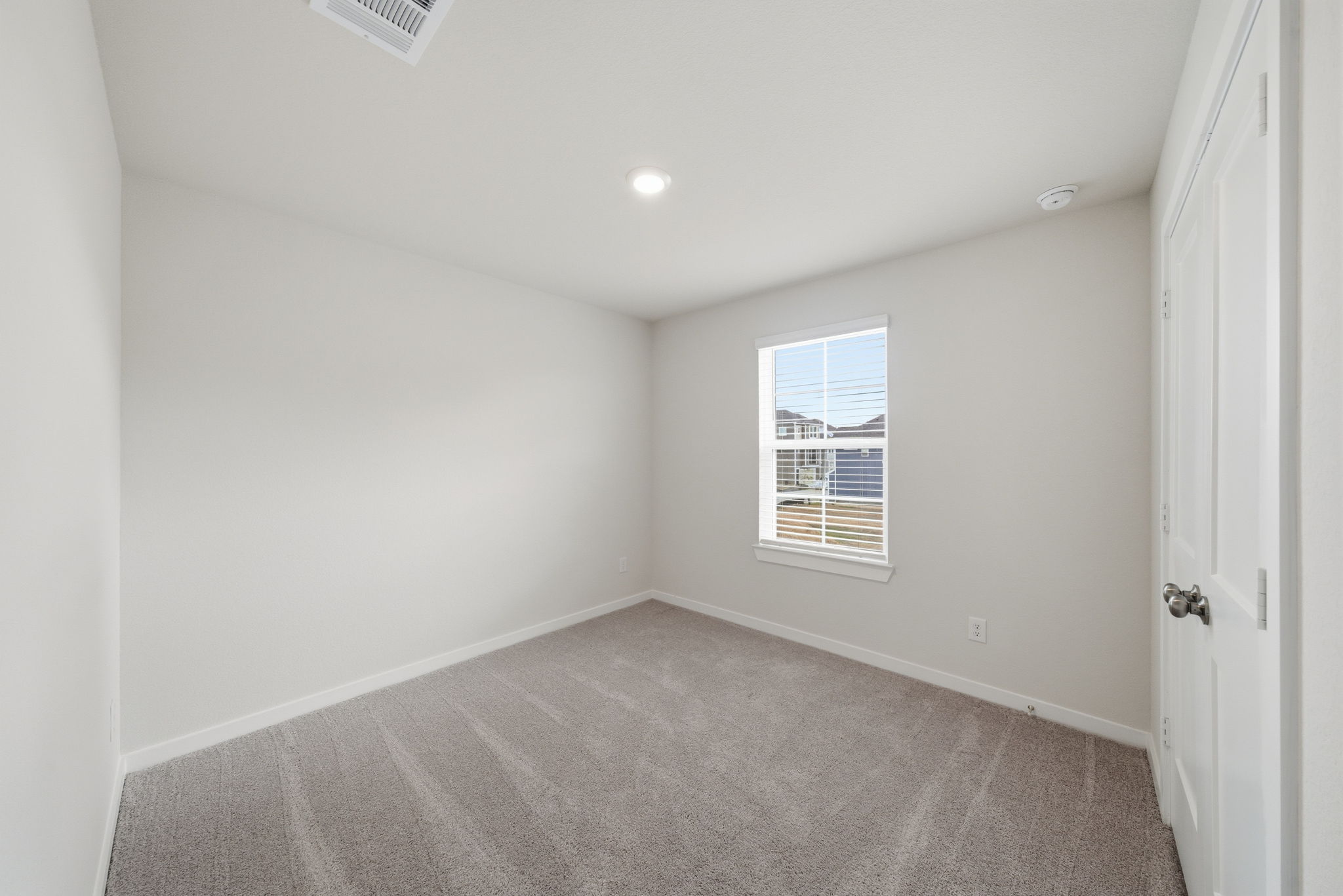 A room with a carpet and a window.