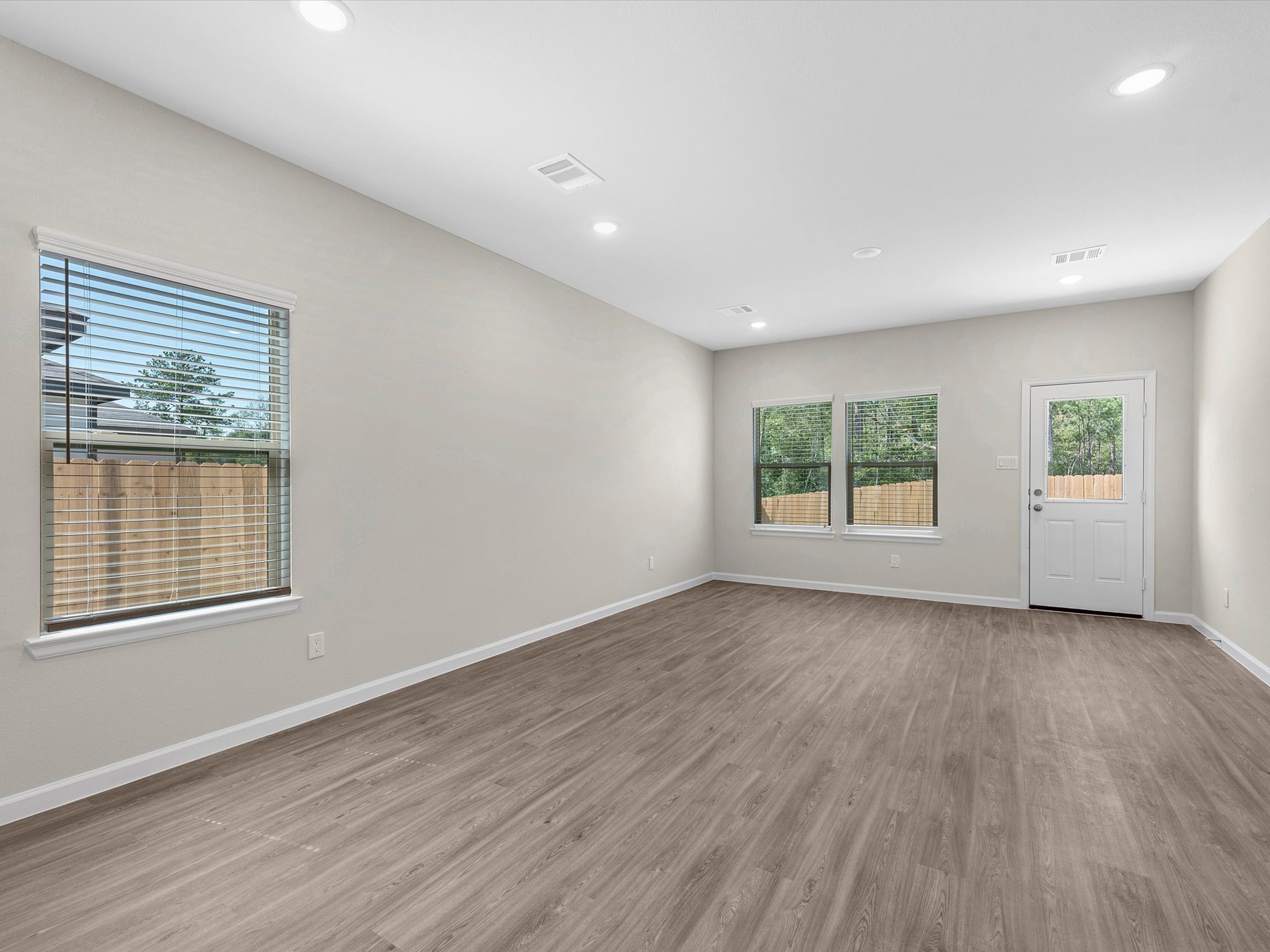 A room with a wood floor and windows.