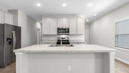 A kitchen with white cabinets.