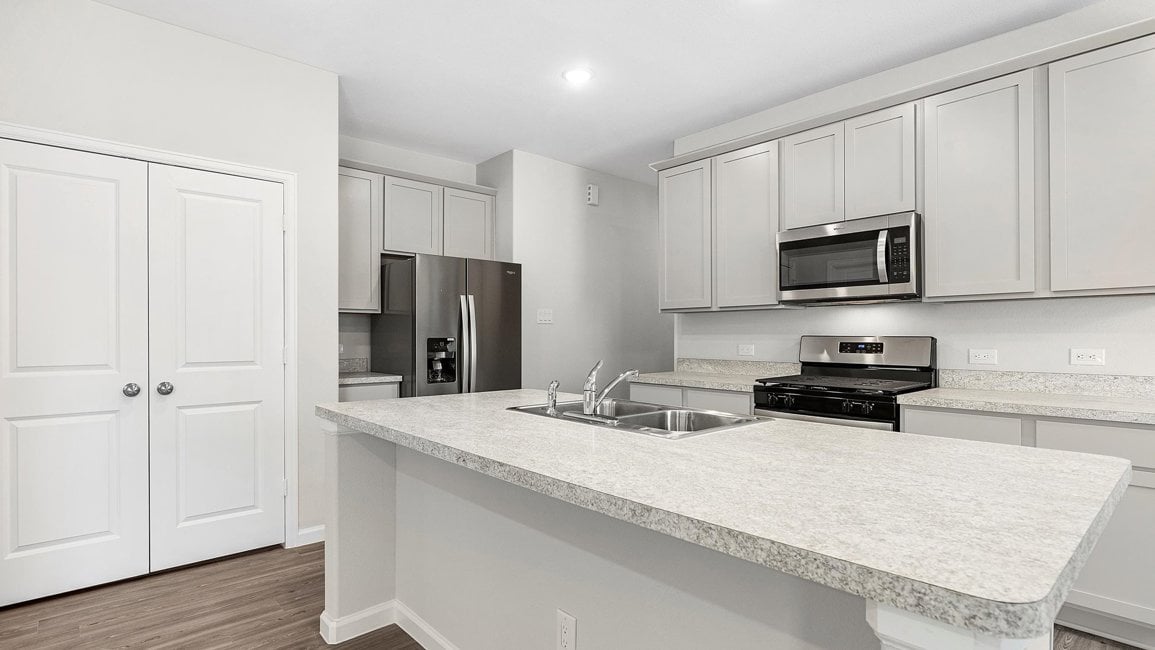 A kitchen with white cabinets.