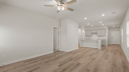 A room with a wood floor and a ceiling fan.