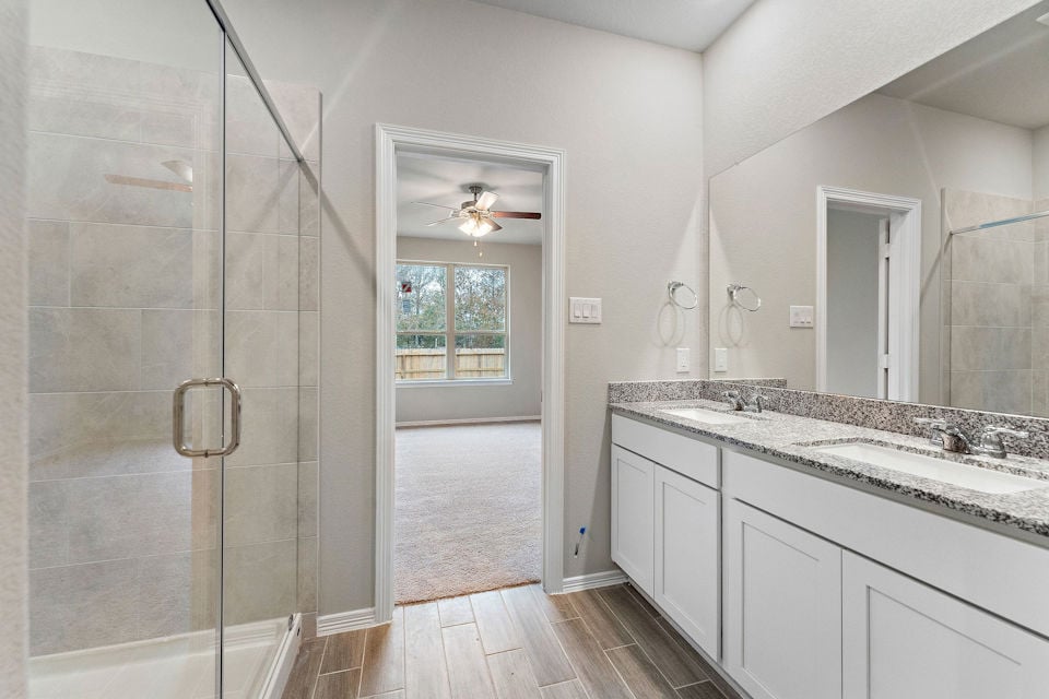A bathroom with a shower unit and a glass door.
