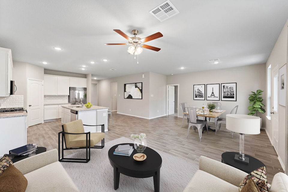 A large living room with a ceiling fan and a table.