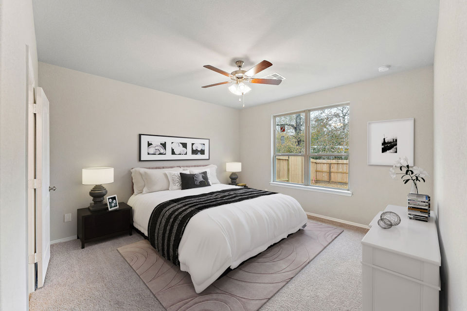 A bedroom with a bed and a fan.