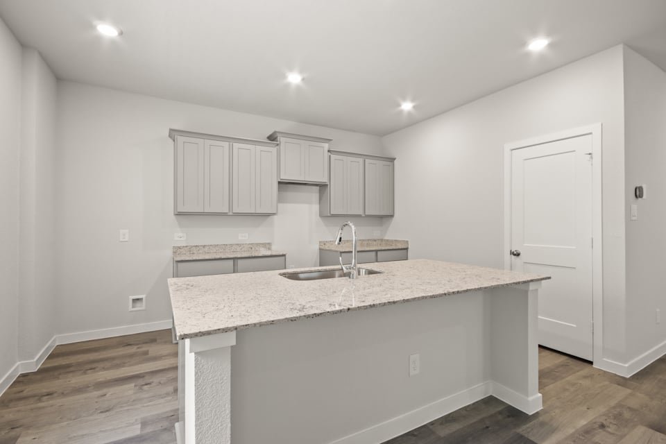 A kitchen with white cabinets.
