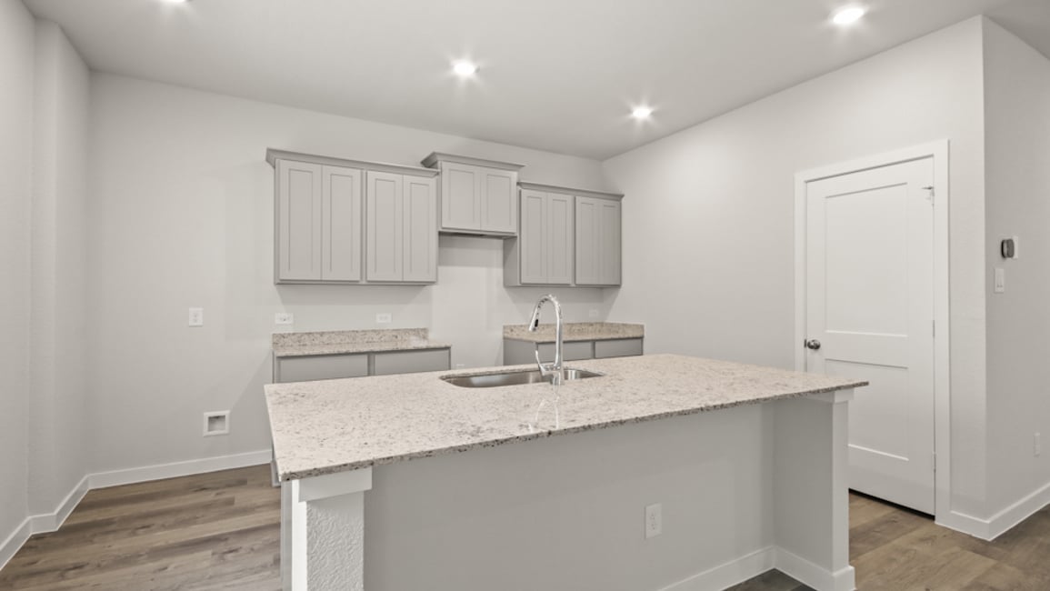 A kitchen with white cabinets.