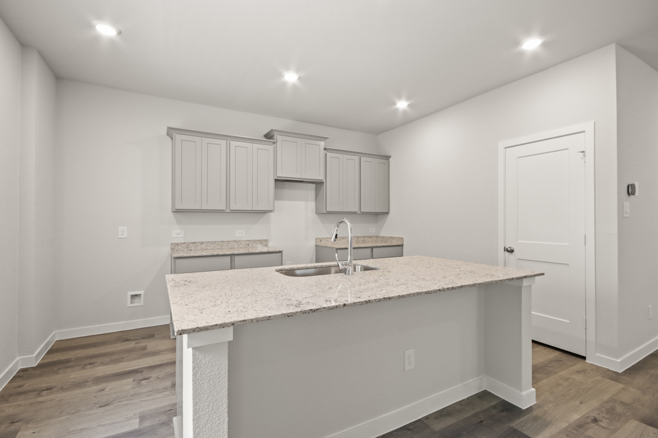 A kitchen with white cabinets.