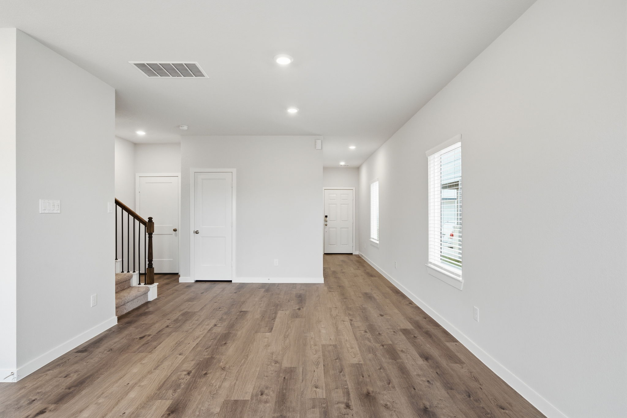 A long hallway with white doors.