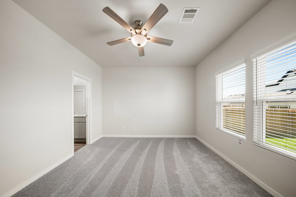 A room with a ceiling fan and a window.