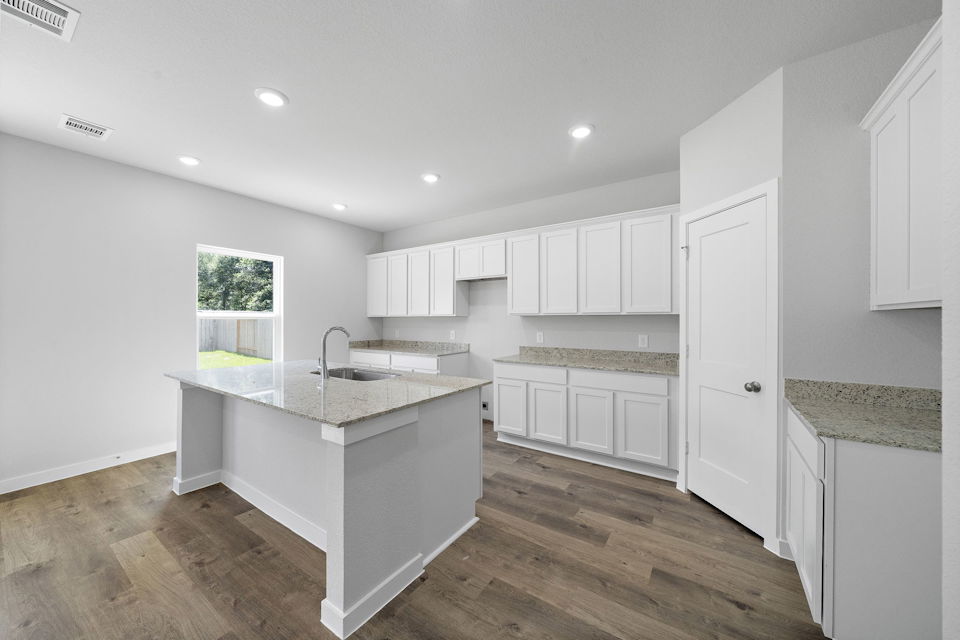 A kitchen with white cabinets.