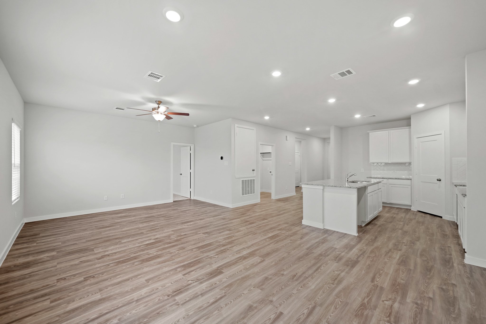 A large empty room with white cabinets.