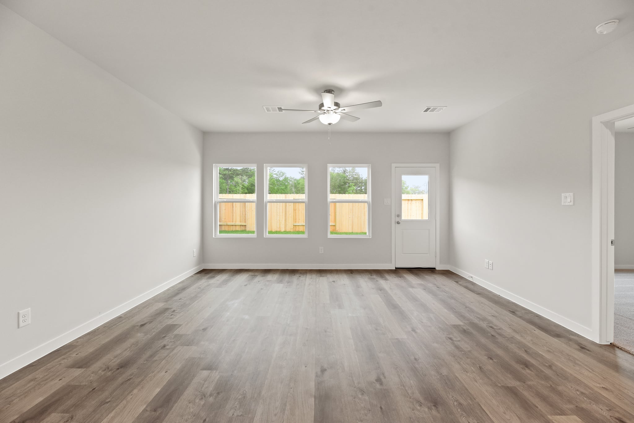 A room with a wood floor and a ceiling fan.