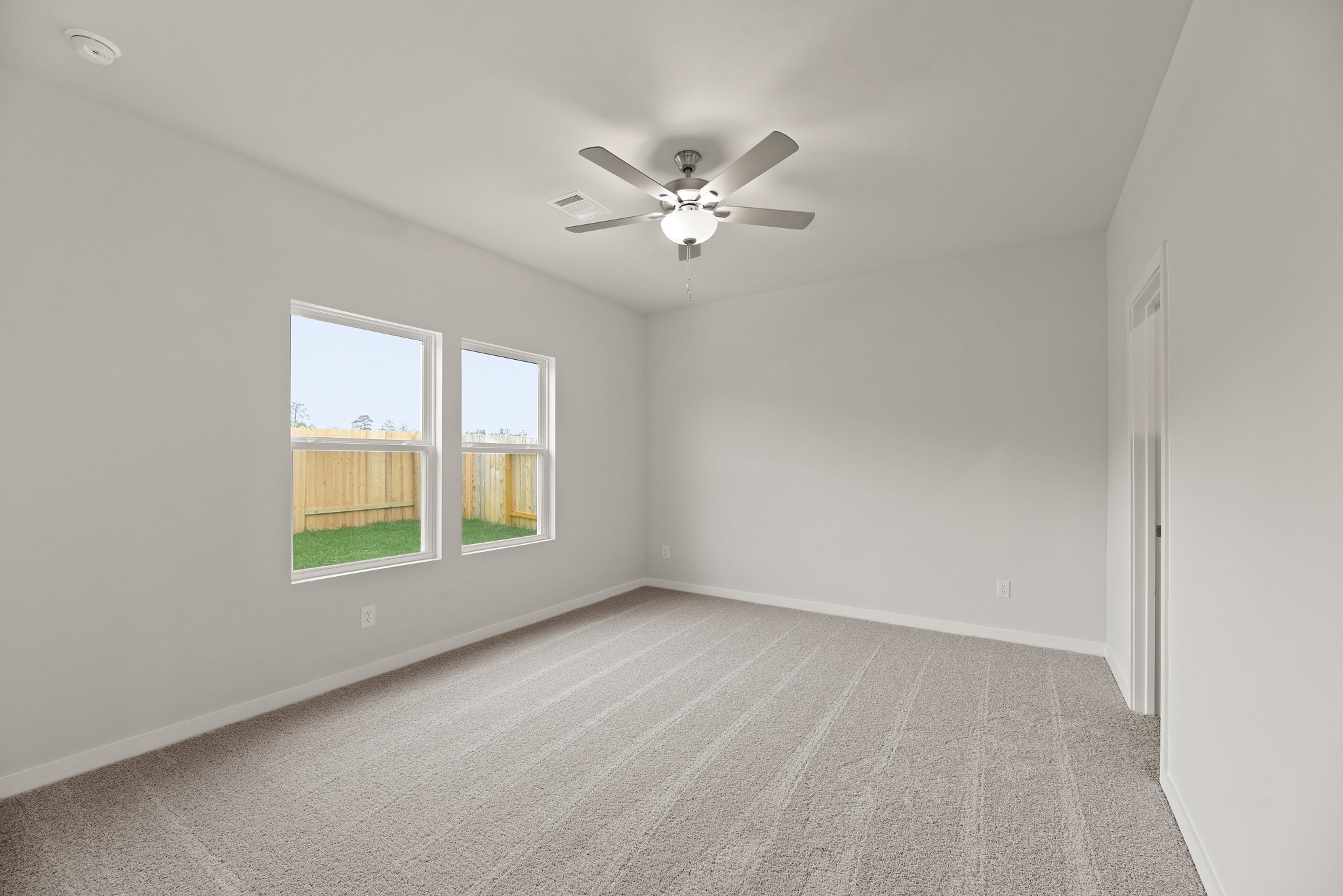 A room with a ceiling fan and a window.