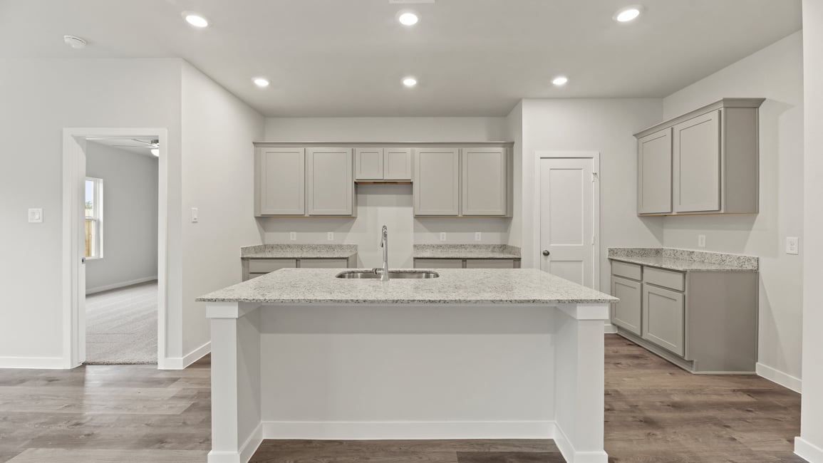 A kitchen with white cabinets.