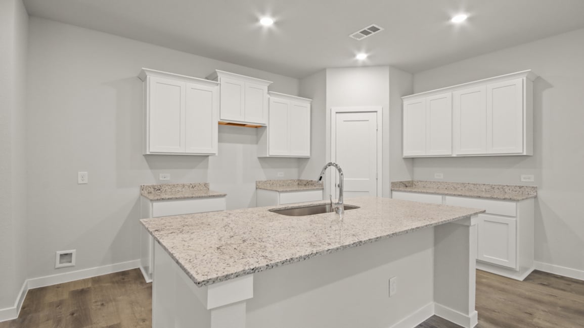 A kitchen with white cabinets.