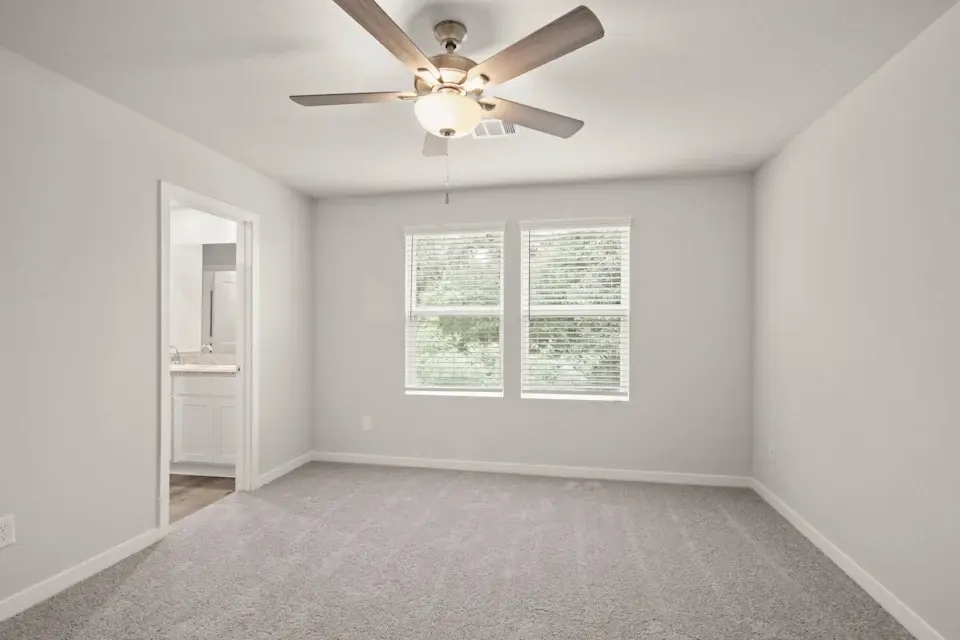 A room with a ceiling fan and a window.