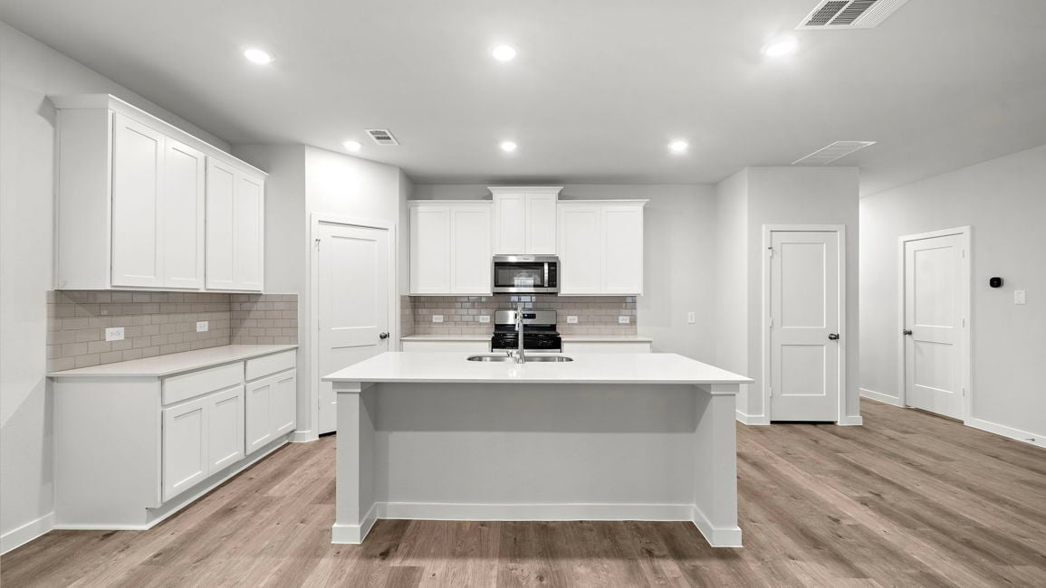 A kitchen with white cabinets.