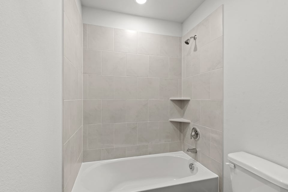 A bathroom with a bathtub and toilet.