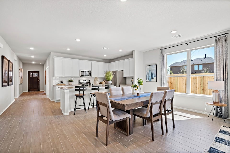 A large kitchen with a dining table.