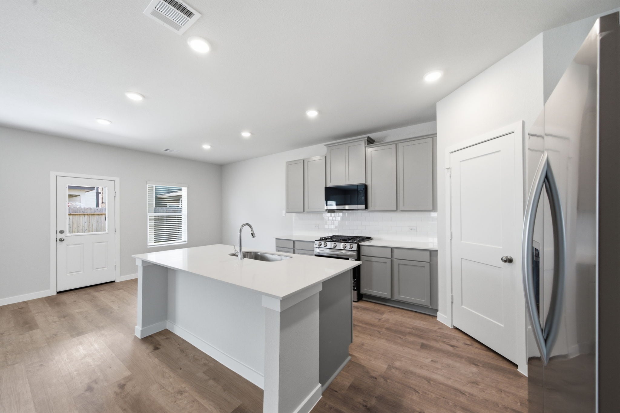 A kitchen with white cabinets.
