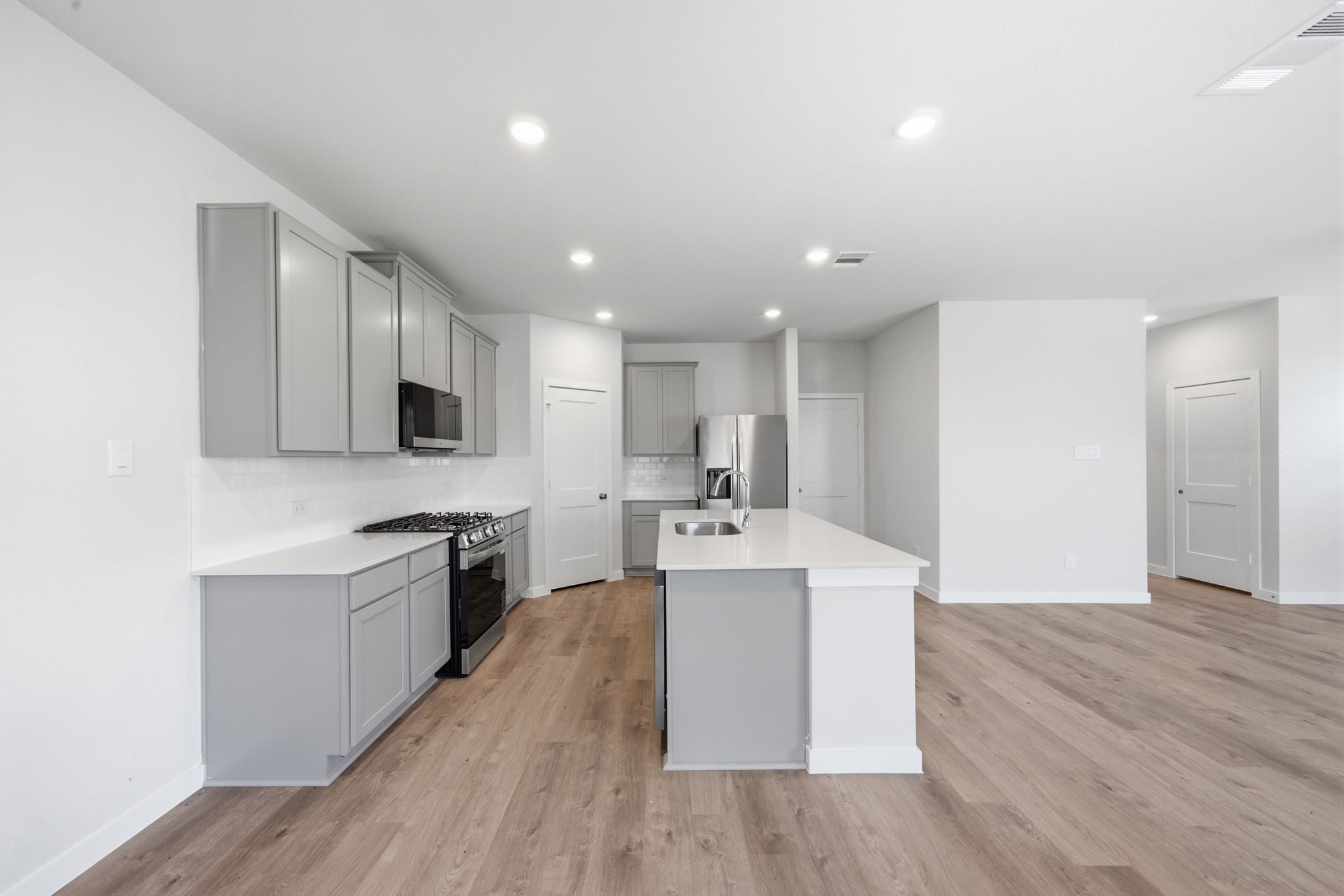 A kitchen with white cabinets.