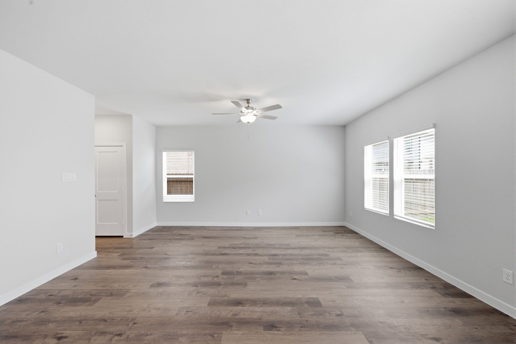 A room with a wood floor and a ceiling fan.