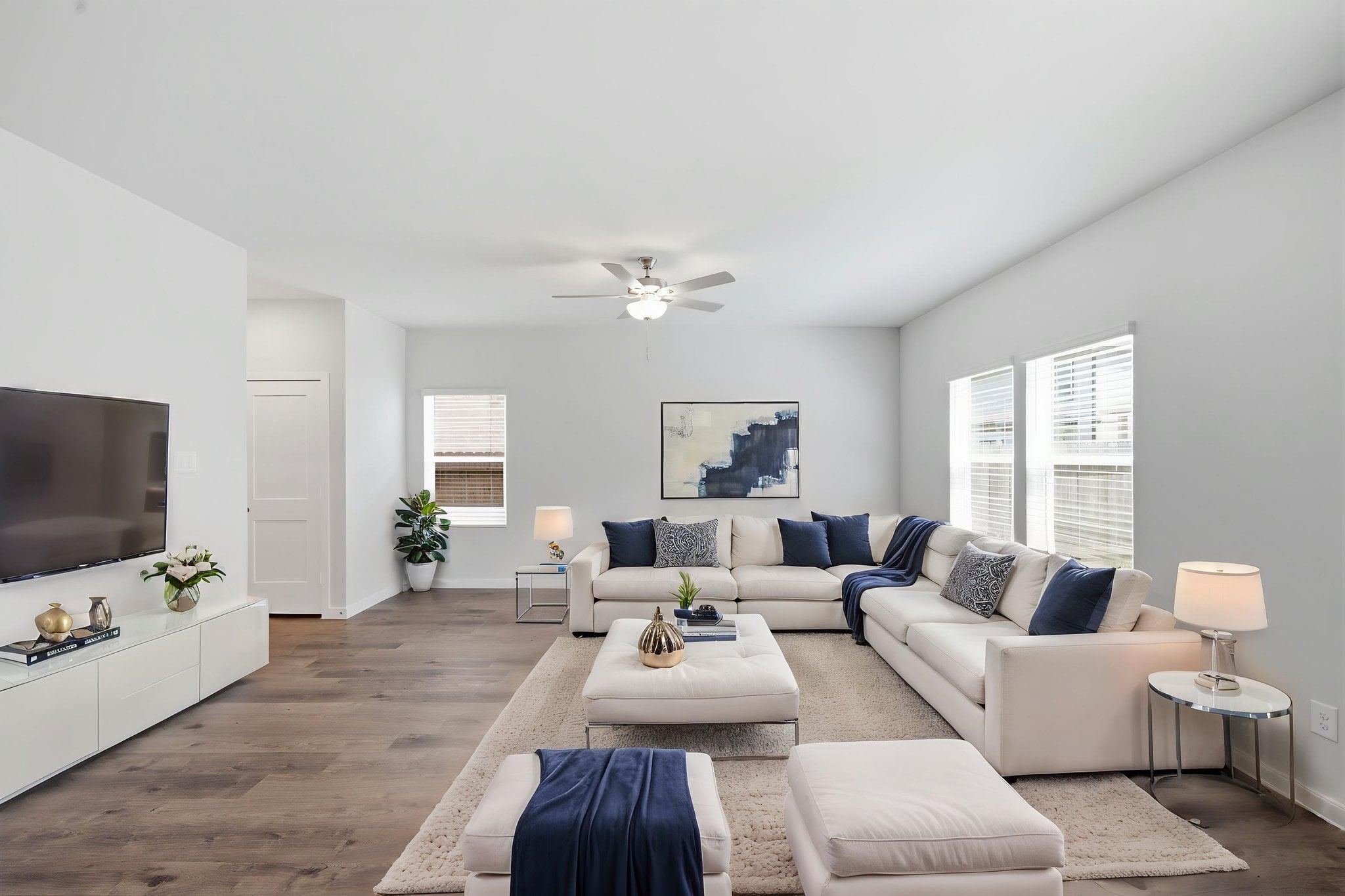 A living room with a large white couch and a tv.