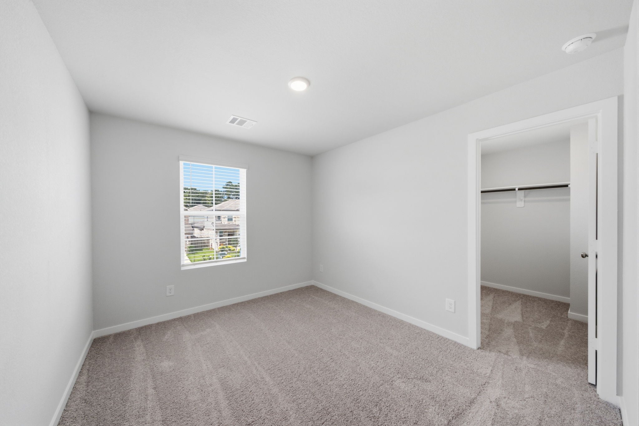 A room with a carpet and a door.
