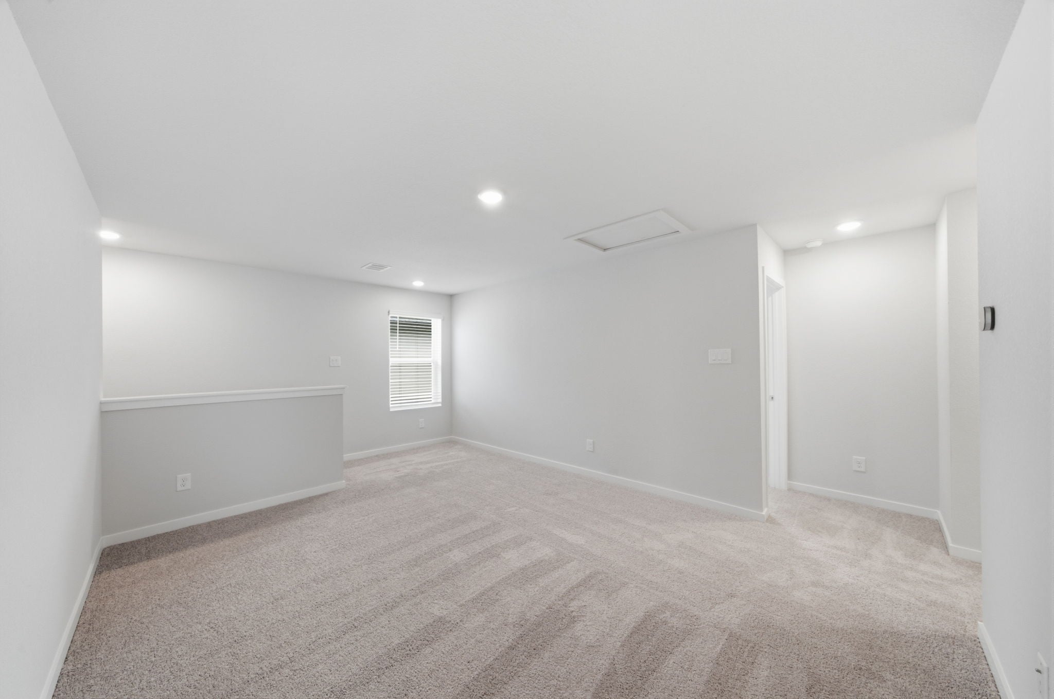 A room with a carpet and a door.