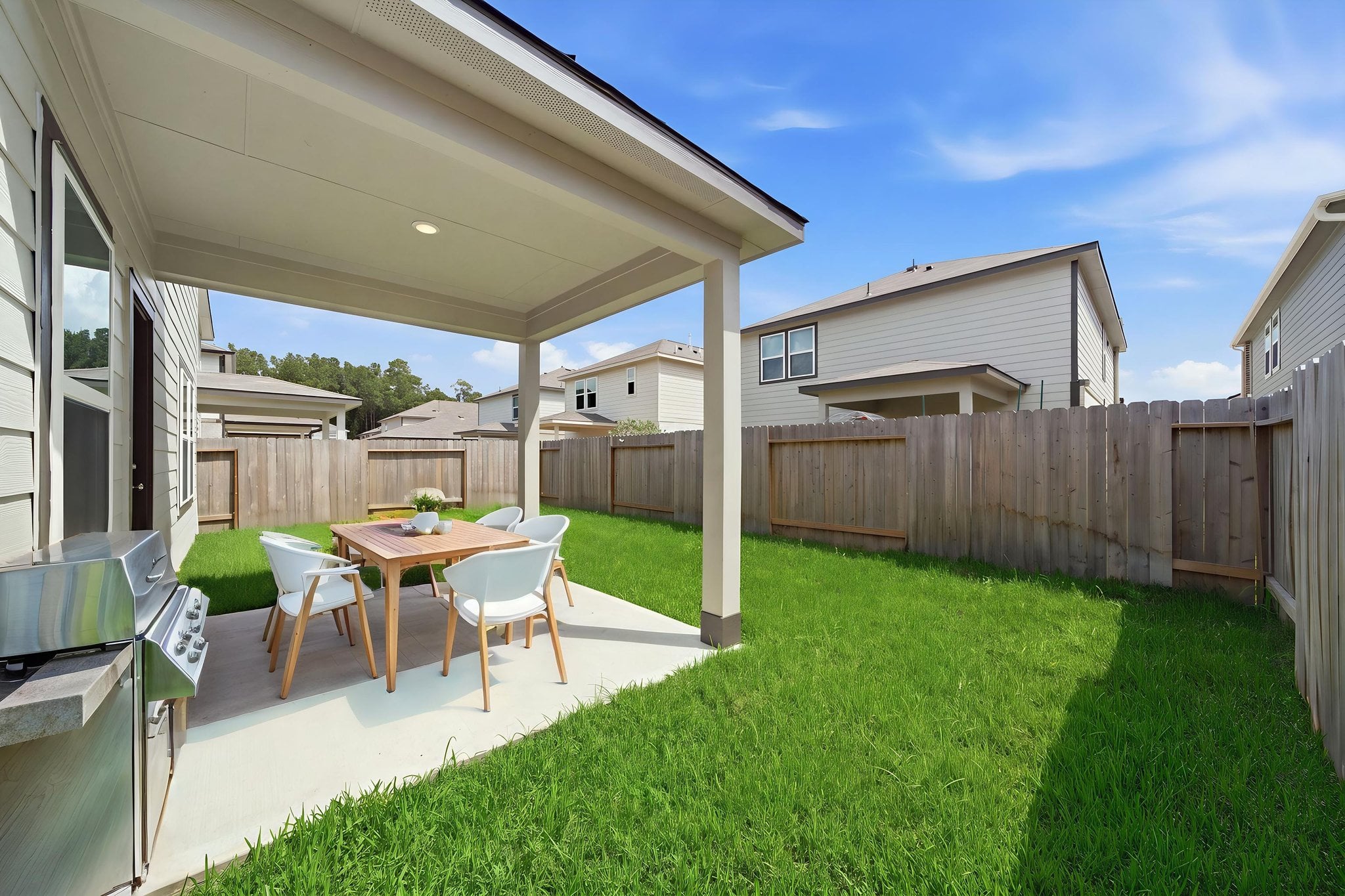 A backyard with a table and chairs.
