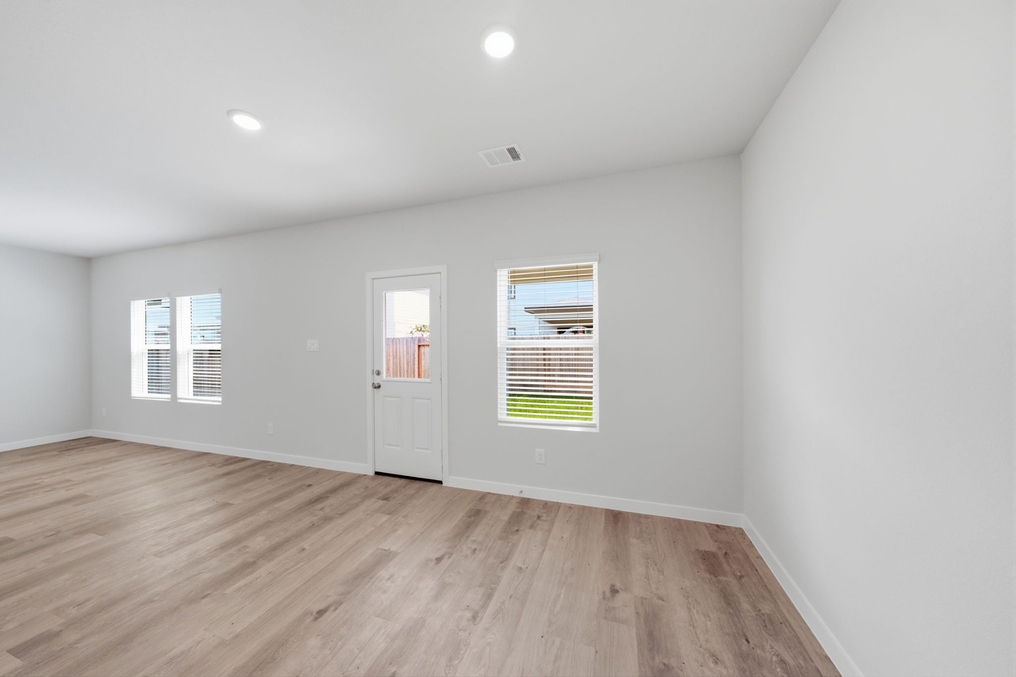A room with a wood floor and a white door.
