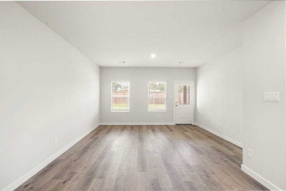 A room with a wood floor and white walls.