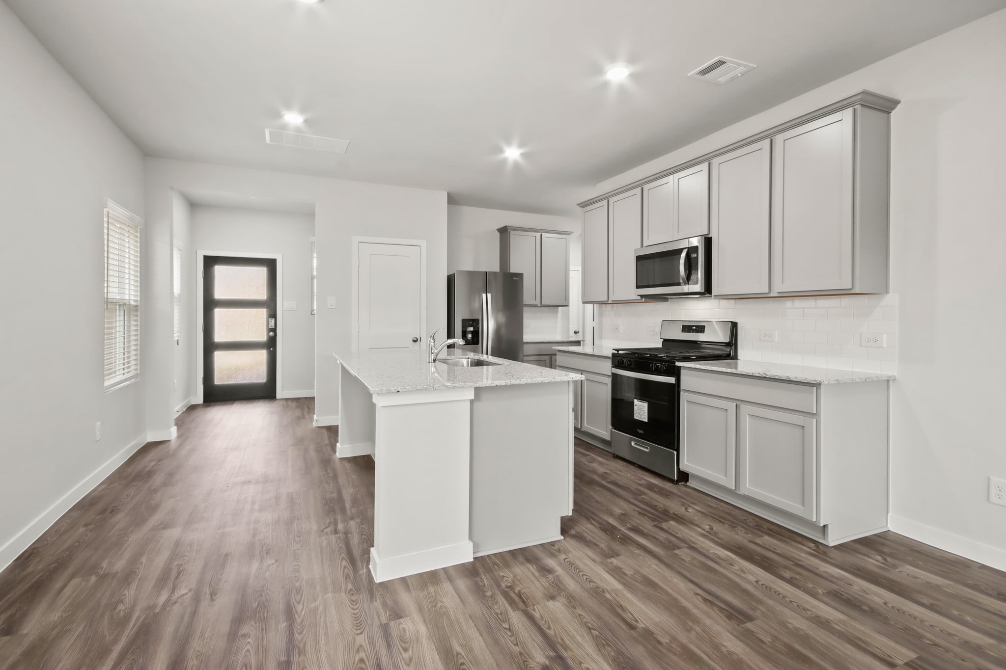 A kitchen with white cabinets.