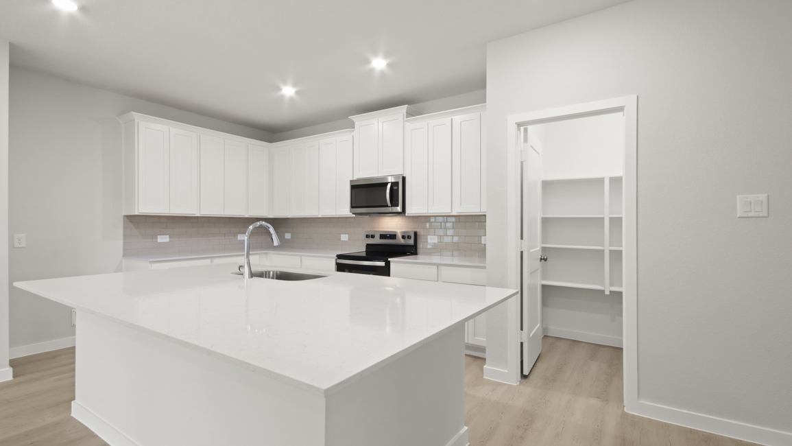 A kitchen with white cabinets.