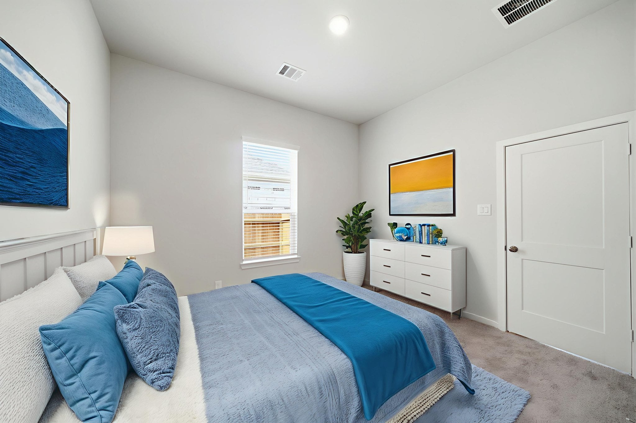 A bedroom with a bed and a plant on the wall.
