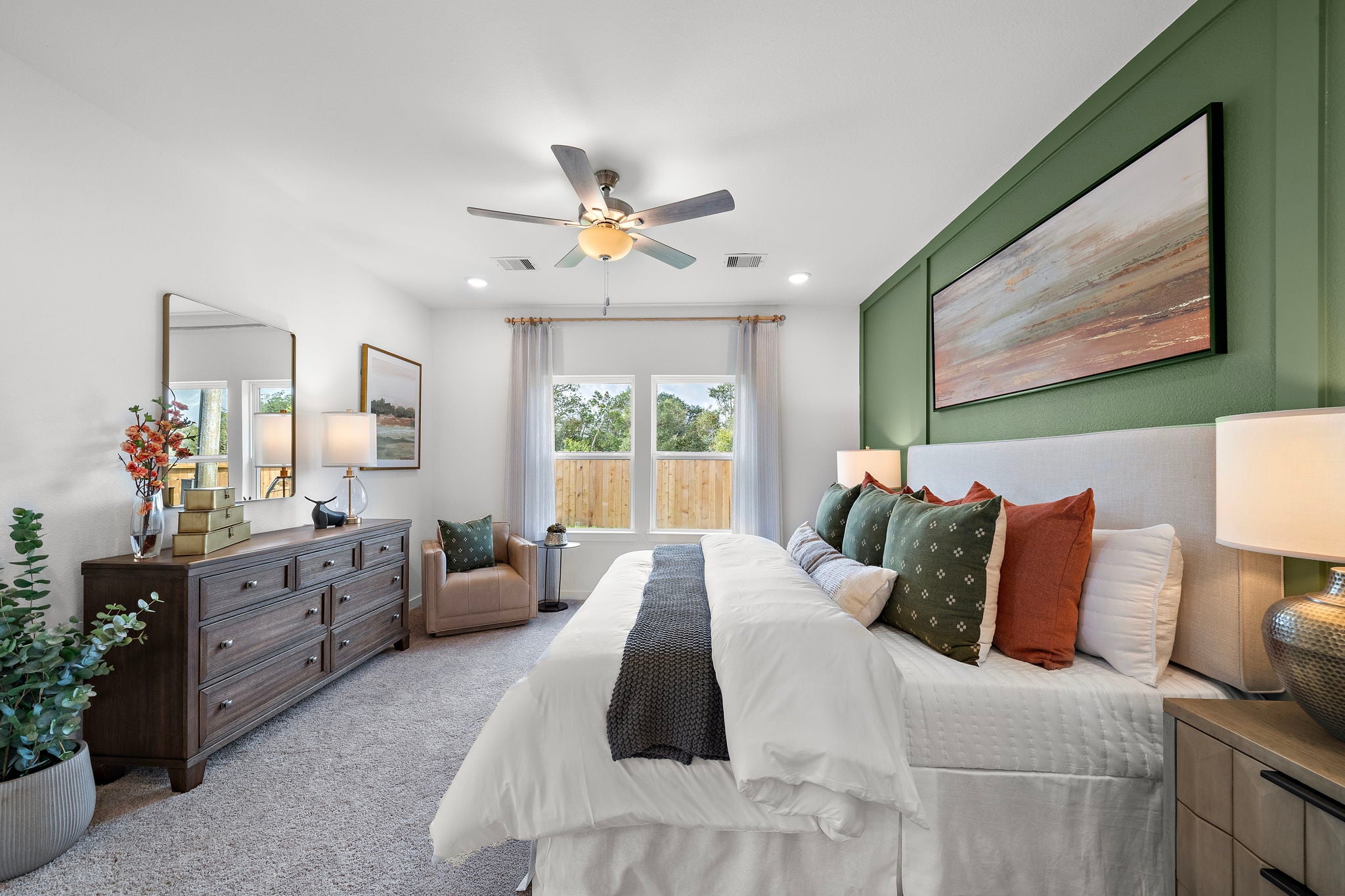A bedroom with a large bed and a fan.
