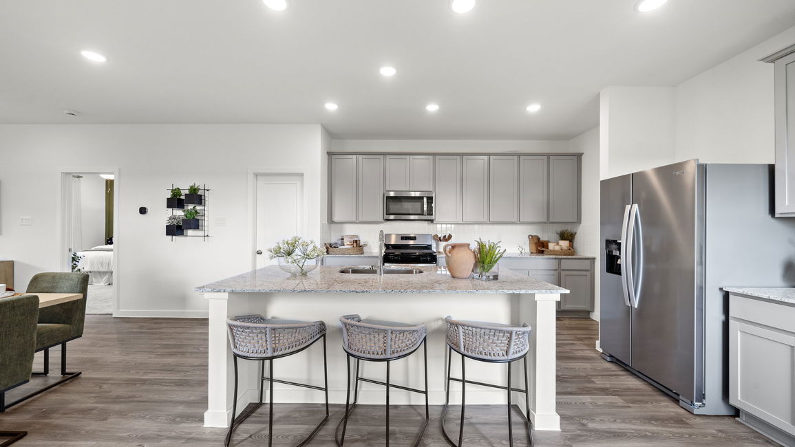 A kitchen with a table and chairs.