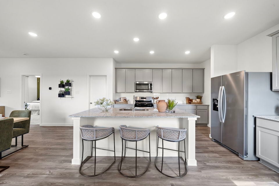 A kitchen with a table and chairs.