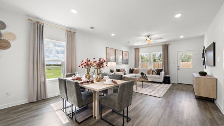 A large living room with a dining table and chairs.