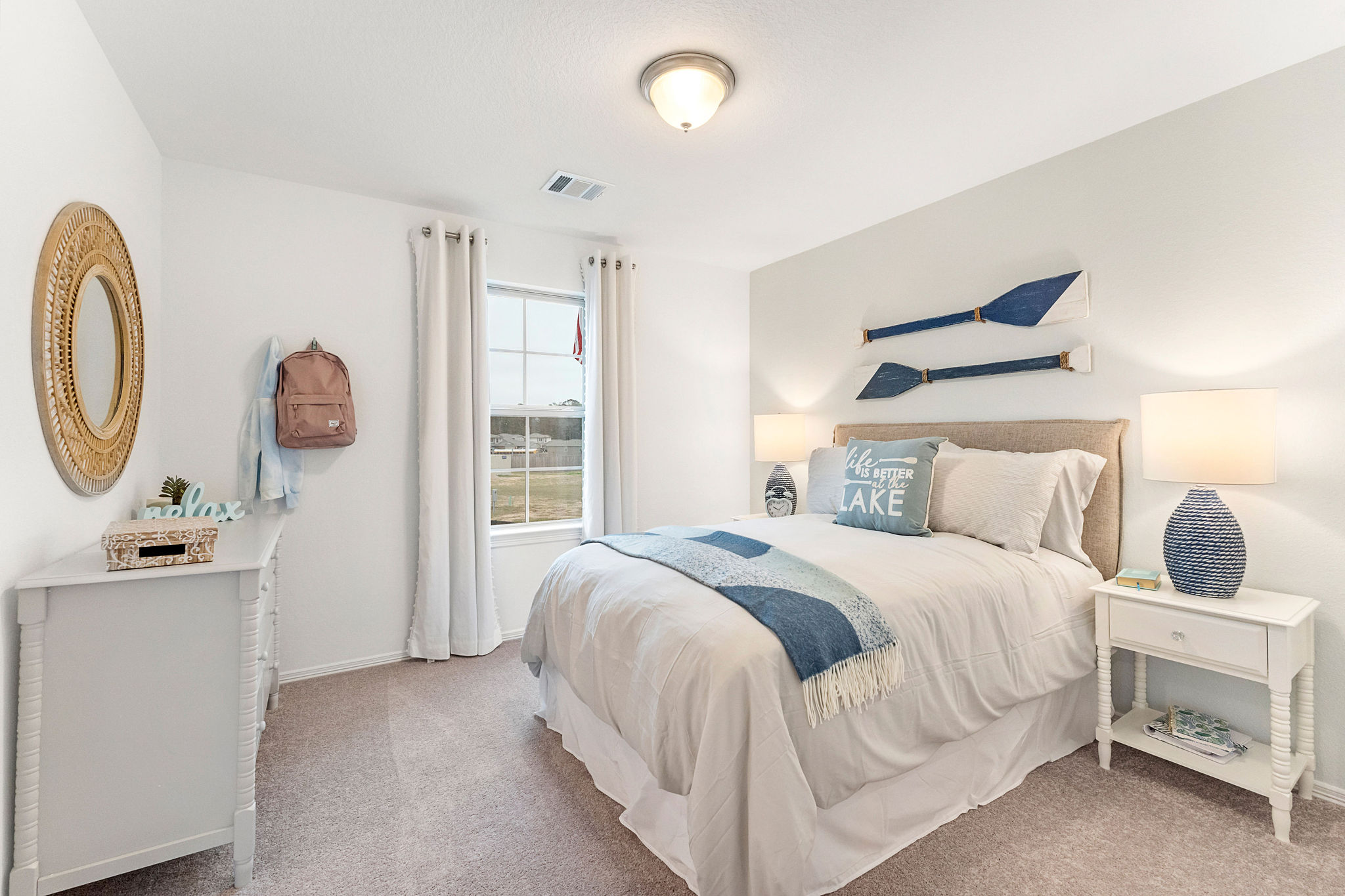 A bedroom with a bed and a mirror.