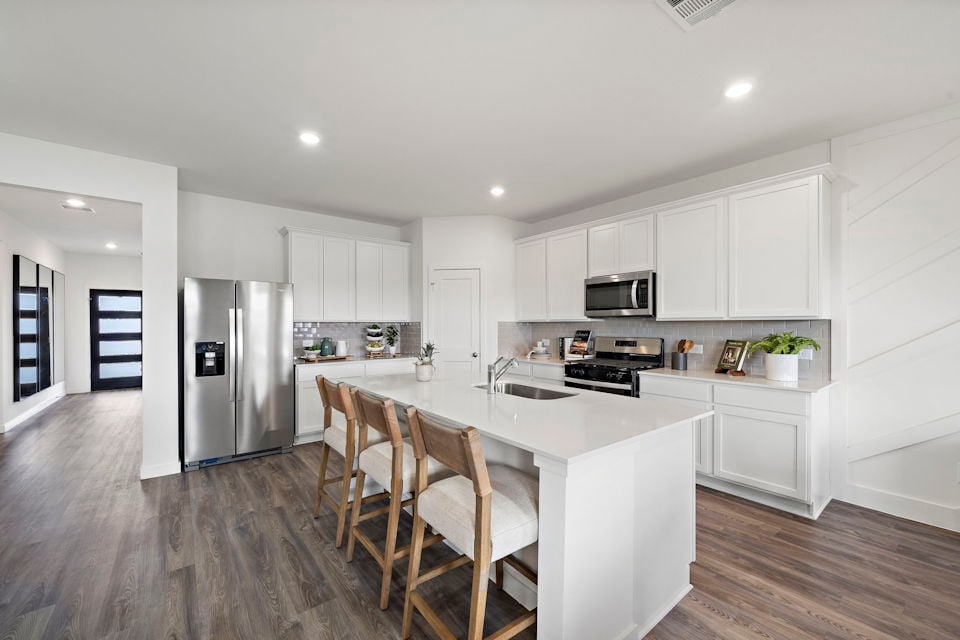 A kitchen with white cabinets.