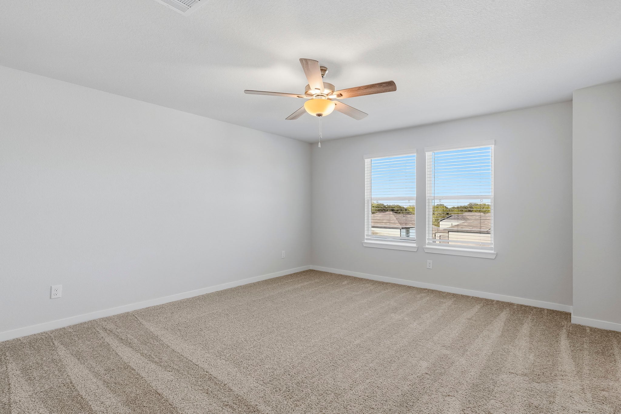 A room with a ceiling fan and a window.