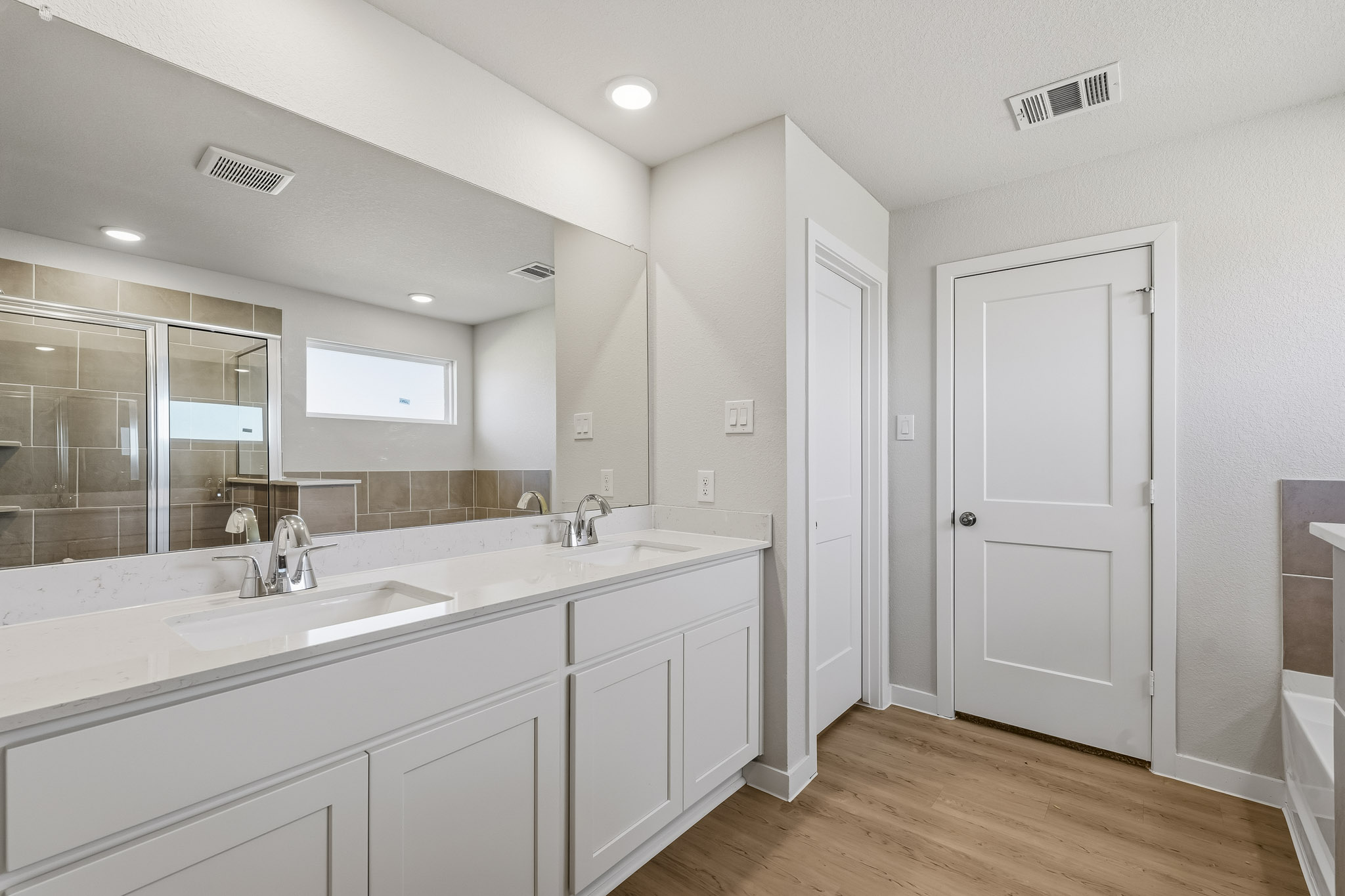 A bathroom with white cabinets.