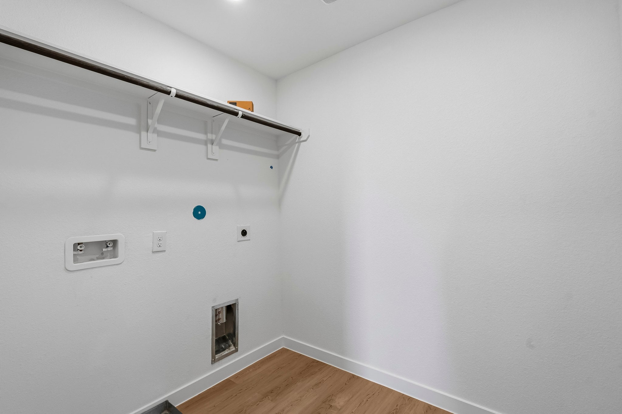 A white room with a wood floor.