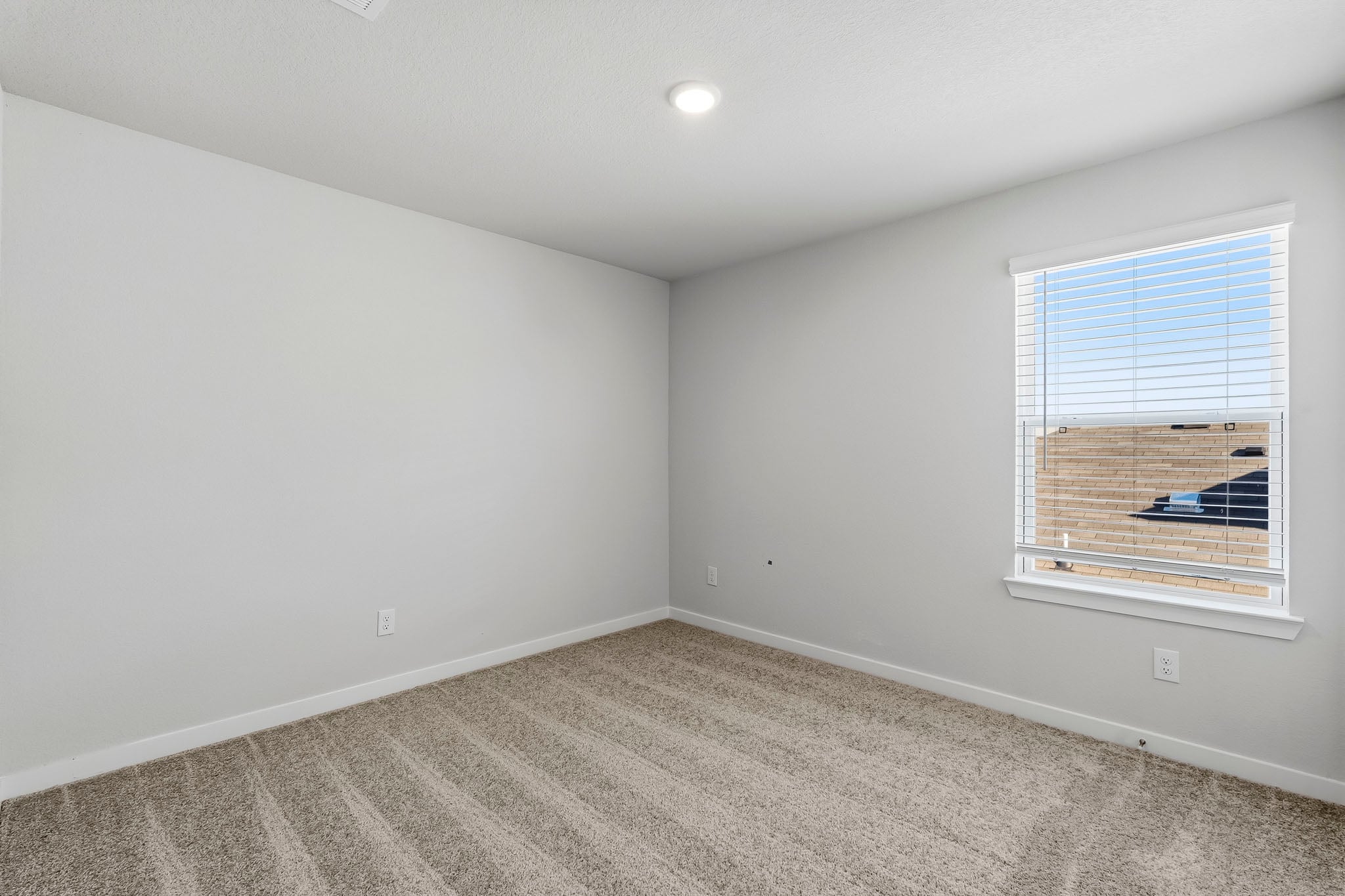A room with a window and a carpet.